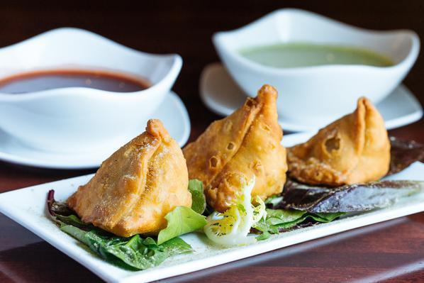 Vegetable Samosa · Crispy fried turnovers deliciously filled with mildly spiced potatoes and green peas.