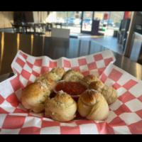 Garlic Knots · Dough tied into knots, and oven baked topped with garlic butter, and served with marinara.