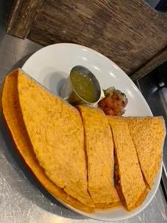 Vegetarian Breakfast Quesadilla · Tomato basil tortilla filled with organic scrambled eggs, pepper jack cheese, red and green peppers, onions and avocado served with tomatillo sauce. Served with red roasted potatoes and grilled onions.