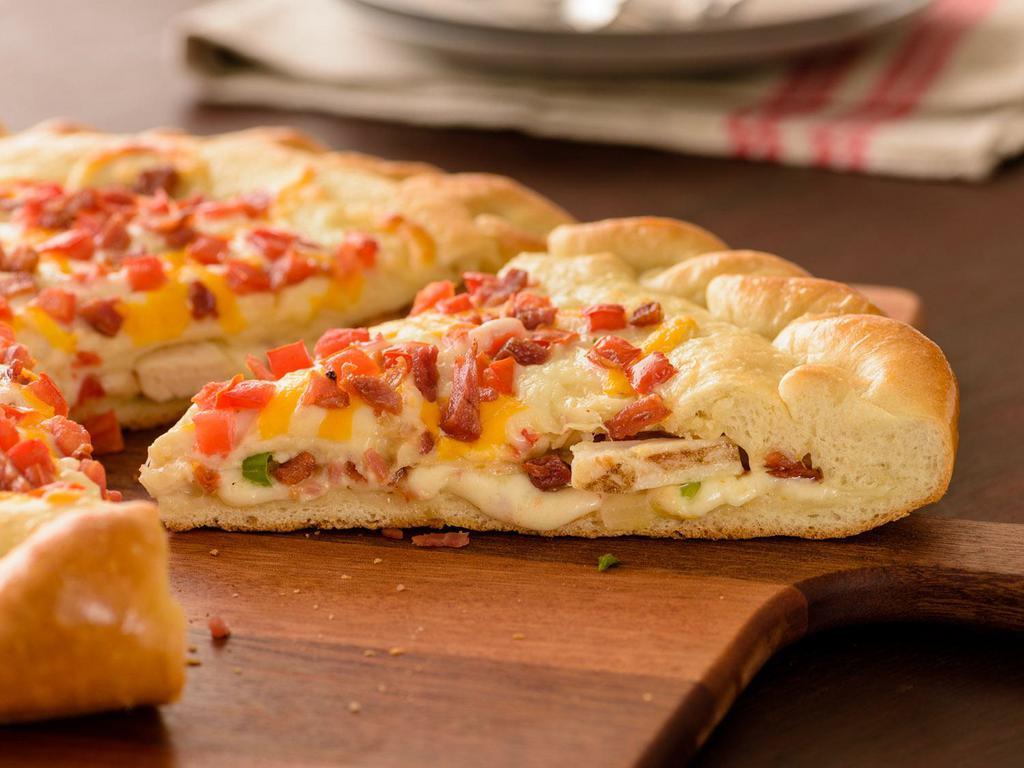 Chicken Bacon Stuffed Pizza (Baking Required) · Two layers of Original Crust stuffed with Chicken, Bacon, Tomatoes, , Mixed Onions, Creamy Garlic Sauce, topped with Tomatoes, Bacon, Creamy Garlic Sauce