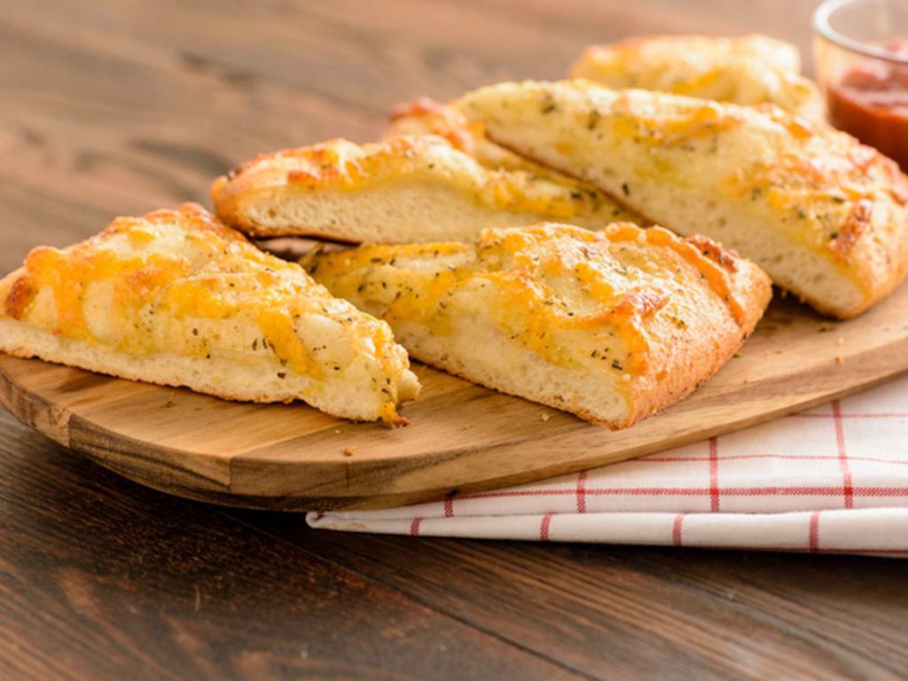 Classic Cheesy Bread (Baking Required) · Fresh dough topped with our Herb Garlic Spread, Whole-Milk
Mozzarella, Mild Cheddar Cheese, and Herb & Cheese Blend served with a side of Marinara.