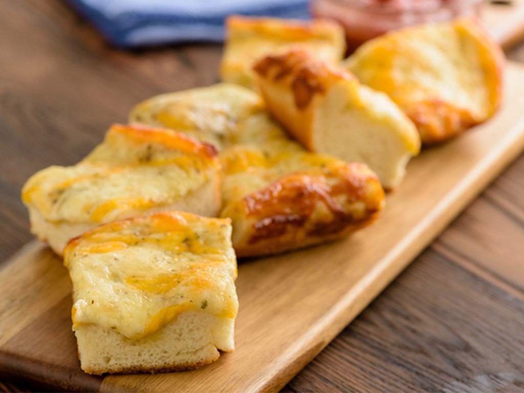 Scratch-Made 5 Cheese Bread (Baking Required) · Fresh dough topped with our Herb Garlic Spread, ¼ pound of Whole-Milk Mozzarella, Herb & Cheese Blend, and Mild Cheddar Cheese served with a side of Marinara.
