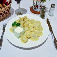 Chicken Pelmeni · Plump meat ravioli filled with minced chicken and onion, served with sour cream.