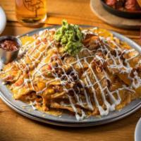 Pulled Pork Nachos · House-fried tortilla chips topped with pulled pork, cheddar cheese, pico de gallo, black bea...