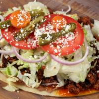 Huarache · Fried masa base with beans, lettuce, sour cream, Cotija cheese, tomato, onion, jalapeno, and...
