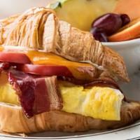 Eggs & Bacon Croissant Sandwich · Bacon, two fried eggs, sliced tomatoes, melted cheddar, and mayonnaise on a flaky croissant....