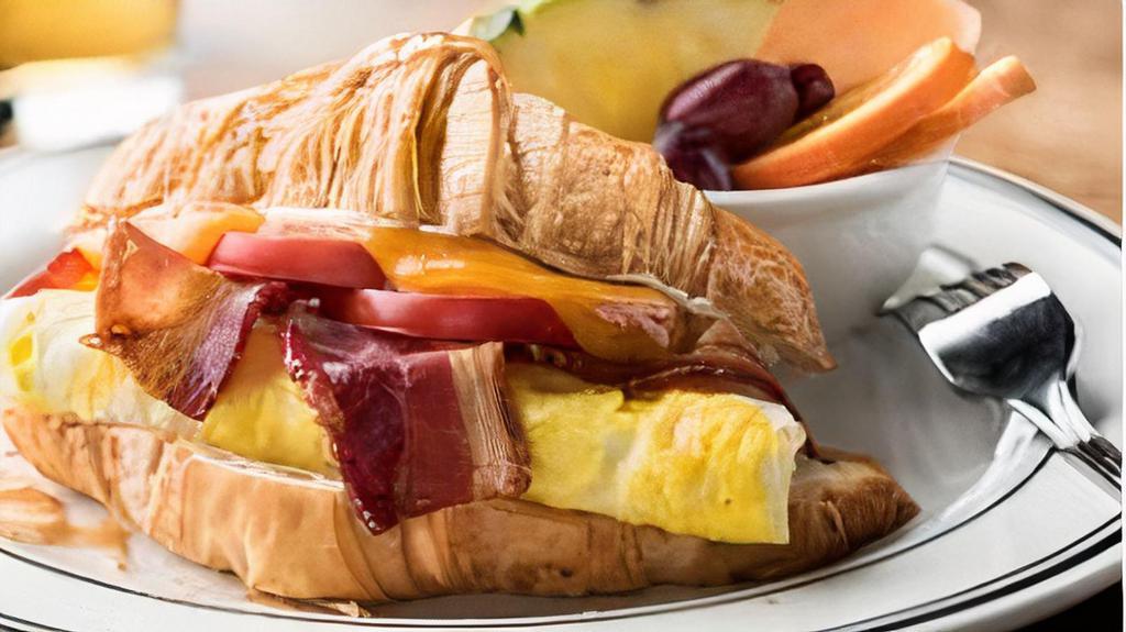 Egg & Bacon Croissant Sandwich · Bacon, two fried eggs, sliced tomatoes, melted cheddar and mayonnaise on a flaky croissant. Served with sliced tomatoes.