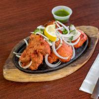 Chicken Tandoori · Marinated chicken breast flavored with herbs and spices cooked in clay oven.