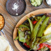 #20.  Fajitas · Marinated chicken or steak. Topped with grilled peppers and onions. Served with beans and ch...