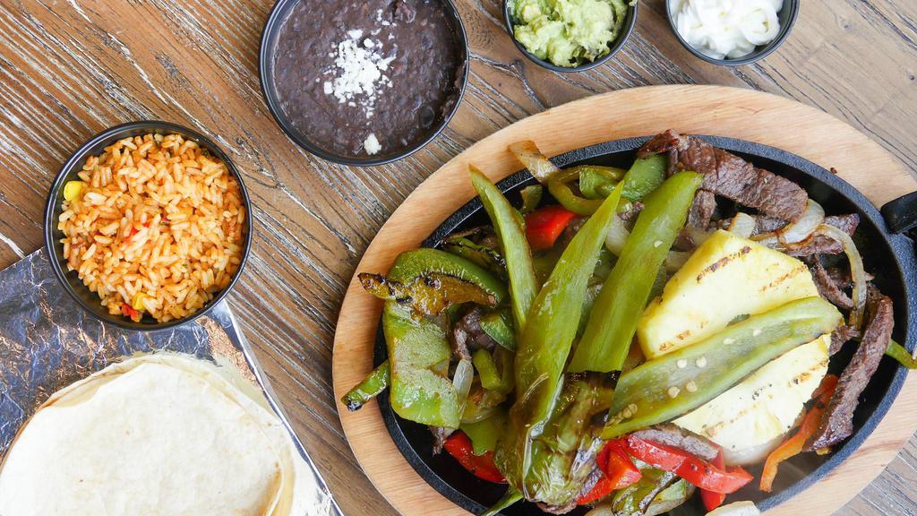 #20.  Fajitas · Marinated chicken or steak. Topped with grilled peppers and onions. Served with beans and cheese, rice, sour cream, pico de gallo and tortillas.