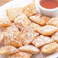 Sopapillas · Puffed Mexican pastries dusted with cinnamon and powdered sugar and served with a side of Ag...