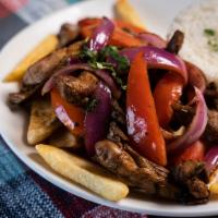 Pollo Saltado · Stir fry chicken with red onions, tomatoes, cilantro served with french fries and white rice.