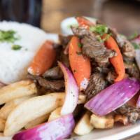 Lomo Saltado · Stir fry steak with red onions, tomatoes, cilantro served with french fries and white rice.