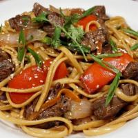 Tallarin Saltado con Carne · A juicy Chinese influenced Peruvian dish made with spaghetti sauteed steak, red onions, toma...