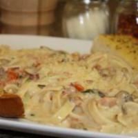 Fettuccine Carbonara · Fettuccini pasta tossed with bacon, scallions, mushrooms and diced tomatoes in a Parmesan cr...