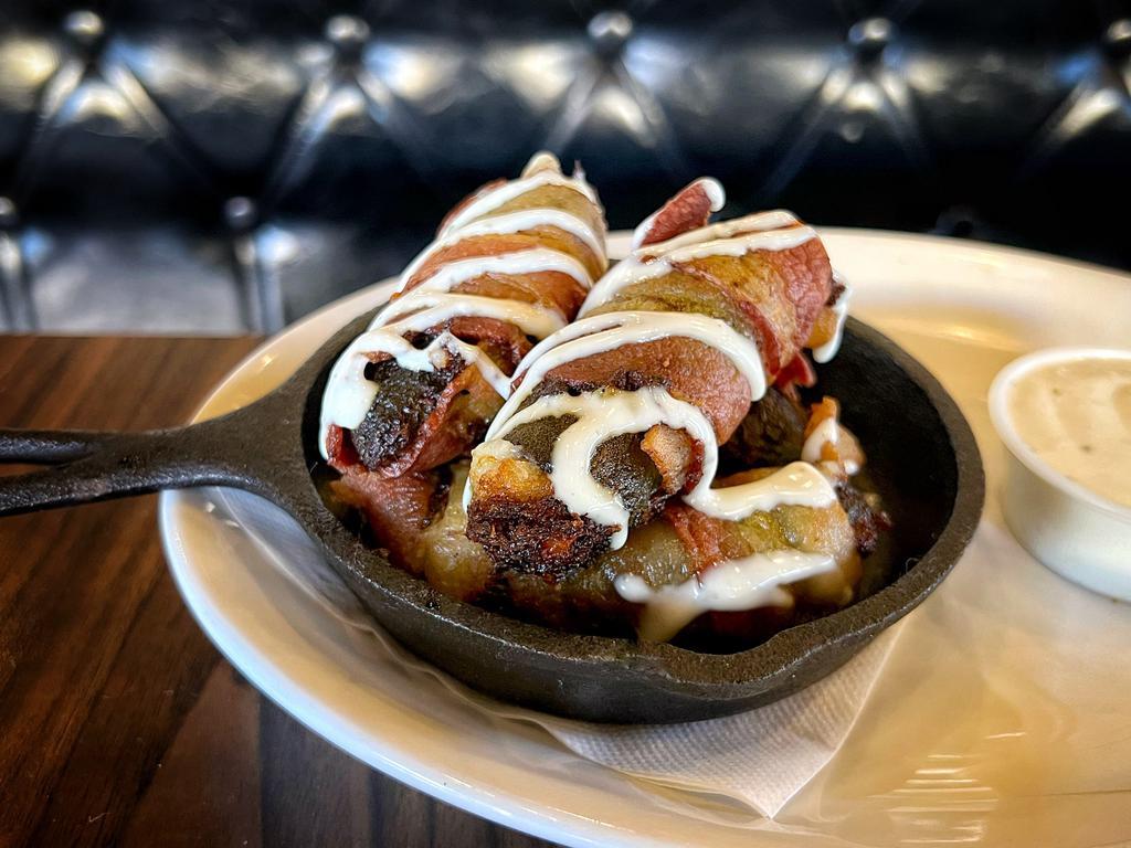 Vampire Jalapeno Poppers · Spicy jalapeños stuffed with our Signature Vampire Dip and wrapped in Hardwood Smoked Bacon, drizzled with house-made ranch dressing