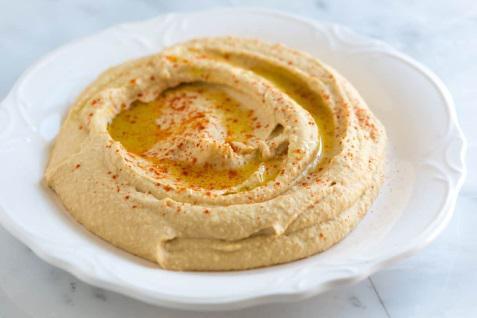 Hummus · Spread made from cooked and mashed chickpeas, blended with tahini, olive oil, lemon juice, salt, and garlic. Served with 2 pita breads.