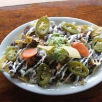  Nachos · Tortilla chips, cheese, black beans, sour cream, guacamole, tomatoes, and pickled jalapenos.