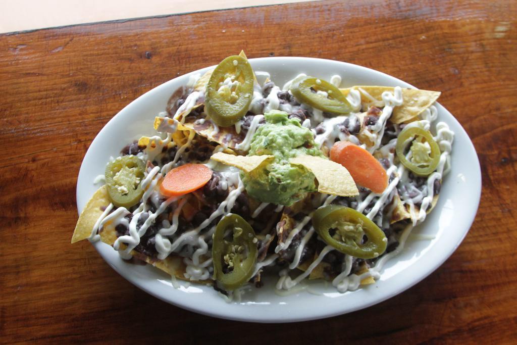 Nachos ·  Tortilla chips, cheese, black beans, sour cream, guacamole, tomatoes, and pickled jalapeños.