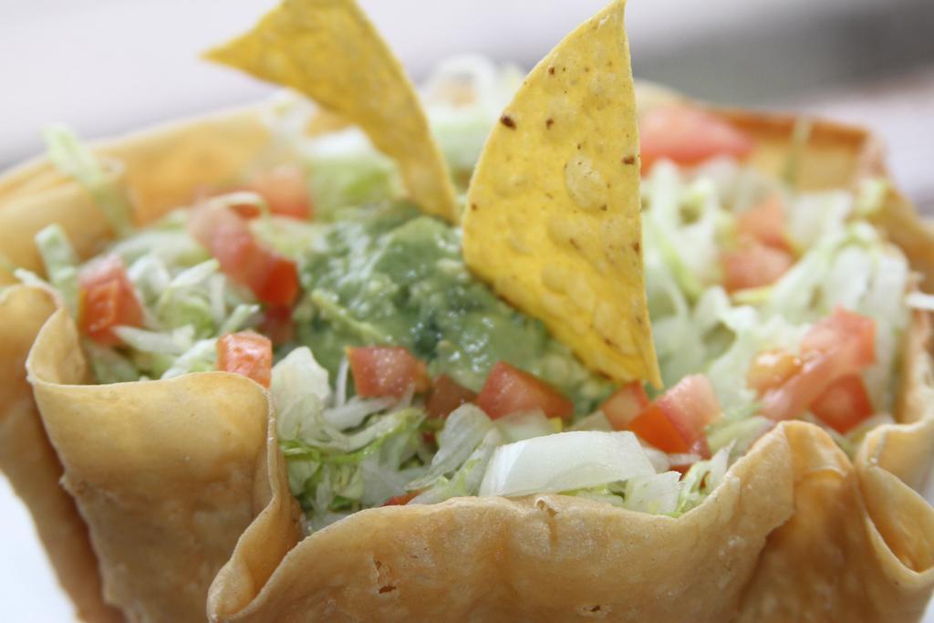 Taco Salad · Tortilla shell filled with beans, rice, lettuce, onions, tomatoes, and guacamole.