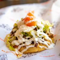 Sope · A corn masa sope filled with your choice of meat, beans, sour cream, tomatoes, Cotija cheese...