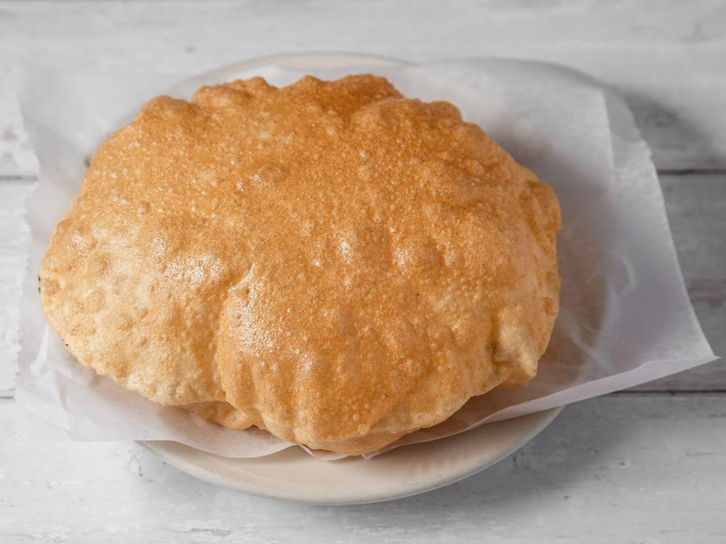 Poori (V) · Deep fried round puffy golden brown whole wheat bread. Vegan.