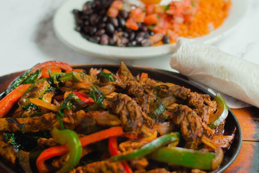 Skirt Steak Fajita Platter · Skirt steak sauteed with bell peppers, onions and chef sauce. Served with rice, beans, guacamole, pico de gallo and sour cream.