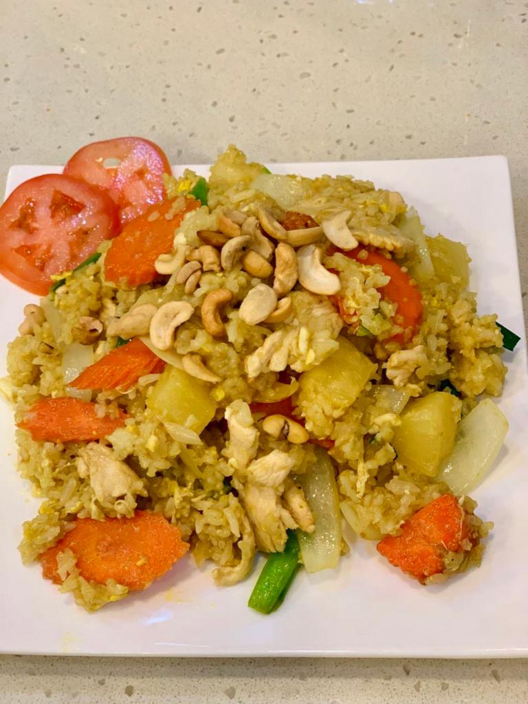 Pineapple Fried Rice Chicken · Thai jasmine rice stir fried with pineapple, carrot, onion, green onion, cashew and raisin in yellow curry served with a house special sauce. 