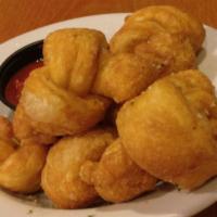 Dough Knots · Garlic buttery rolls sprinkled with Parmesan and Italian spices served with a side of marina...