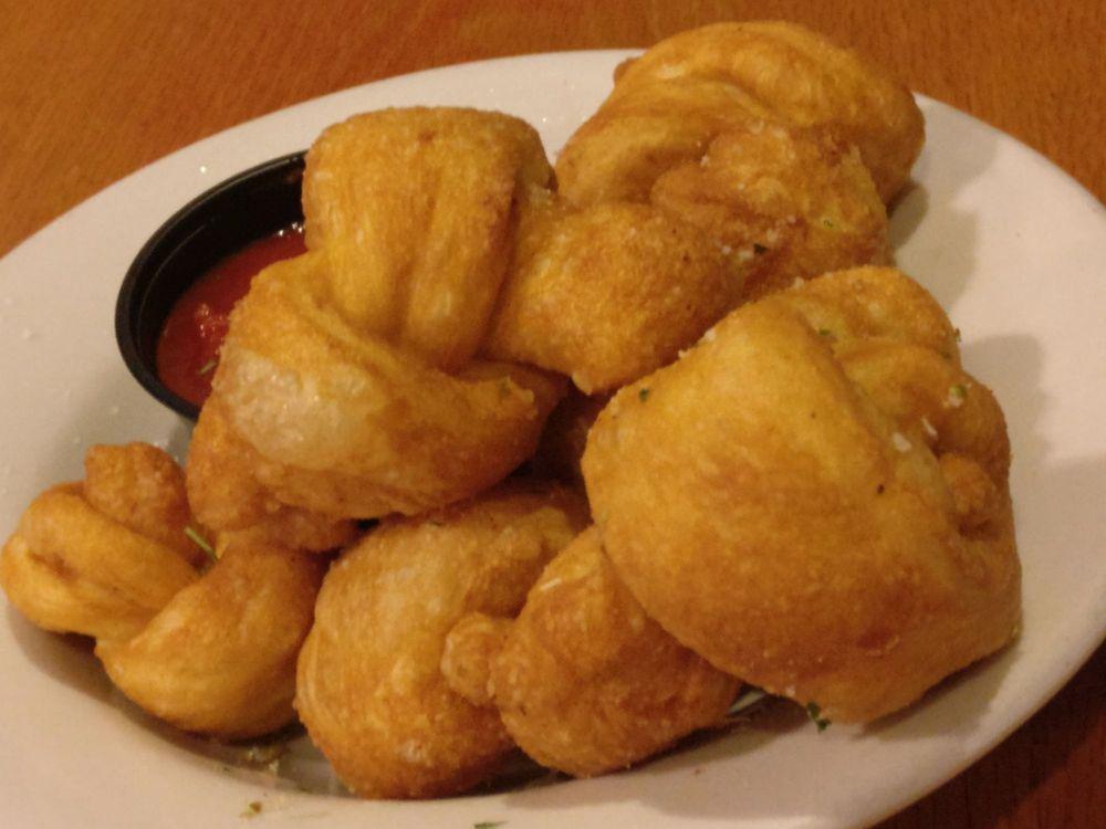 Dough Knots · Garlic buttery rolls sprinkled with Parmesan and Italian spices served with a side of marinara.