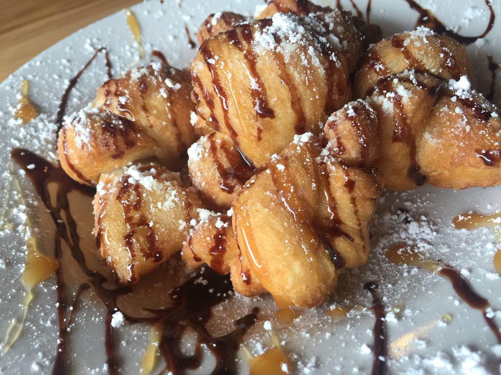 Sweet Knots · Twisted dough knots drizzled with chocolate anddusted with powdered sugar.