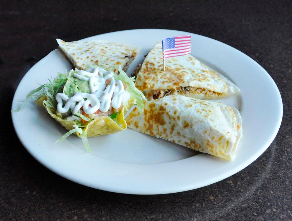Texas Fajita Quesadilla · Marinated steak, chicken and shrimp grilled with onions and bell peppers inside your cheese quesadilla. Accompanied by guacamole salad.