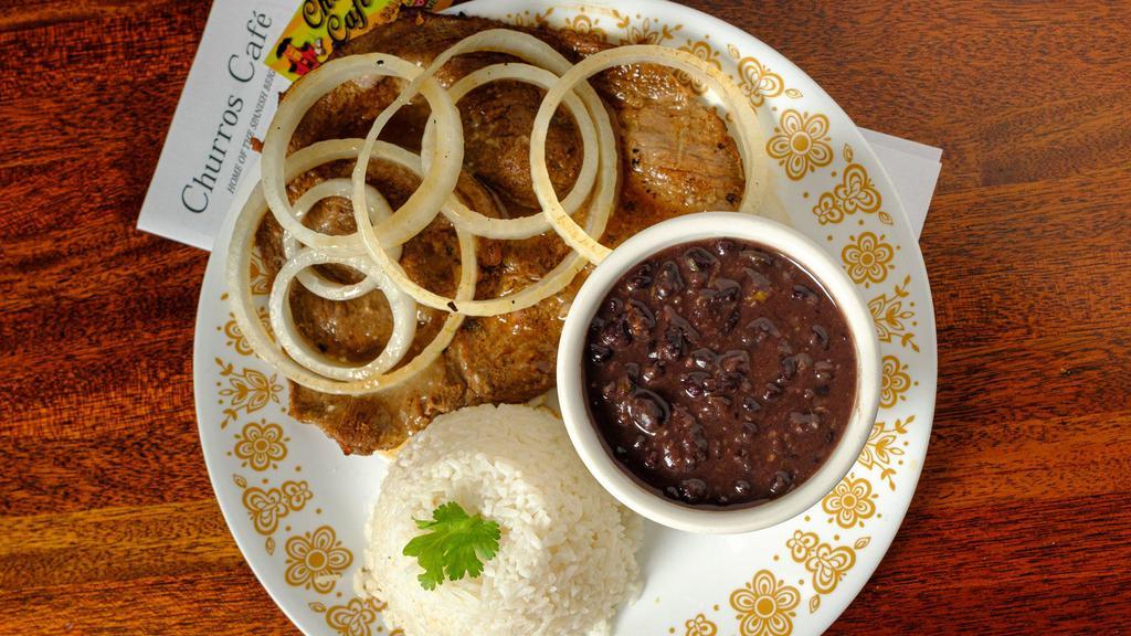 Bistec Encebollado · A thin grilled sirloin steak marinated in sour orange, fresh garlic, onions, and cilantro. Topped with fresh sliced sauteed onions.