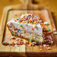 Fruity Pebbles Cheesecake · Funfetti cheesecake in a graham cracker crust topped with whipped cream and glazed fruity pe...