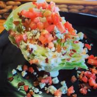 Iceberg Wedge Salad · Buttermilk ranch dressing, diced tomato, crumbled bacon, red onion, and blue cheese crumbles.