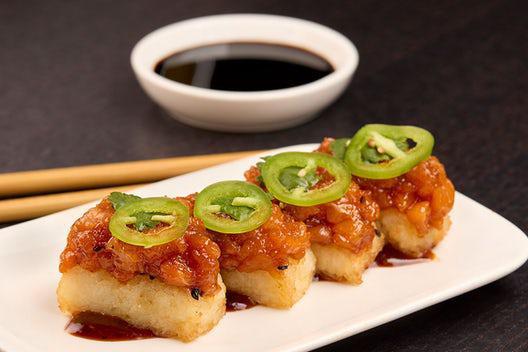 CRISPY SPICY RICE · Crunchy sesame rice balls, jalapeño, cilantro, drizzled with soy chili sauce.


