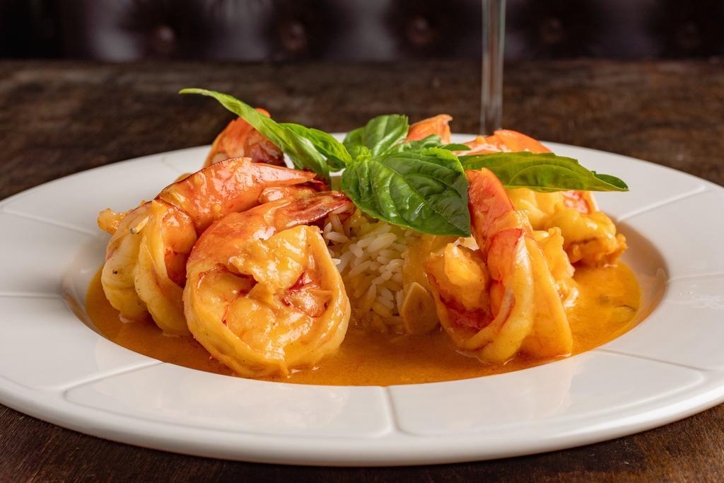 Shrimp Scampi · Jumbo shrimp sauteed with garlic and white wine lemony sauce, over a bed of white rice.