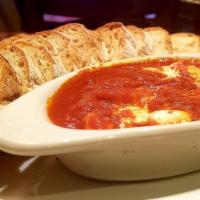 Baked Goat Cheese · Goast cheese baked in our house pomodoro sauce, served with baguette 