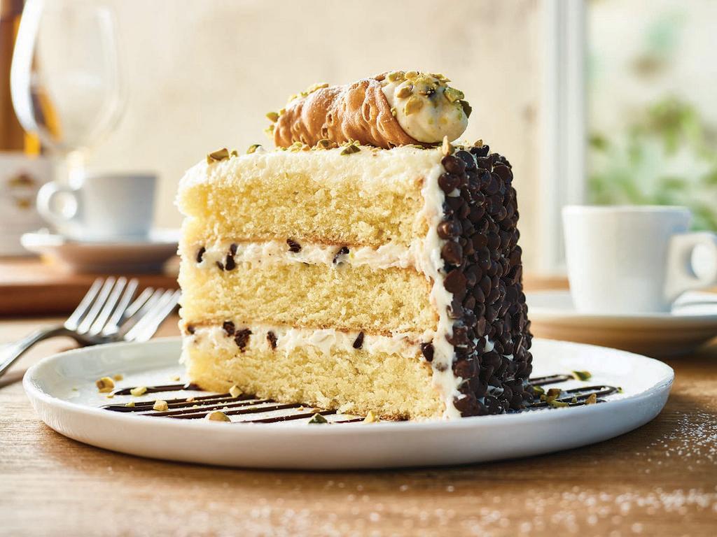 Cannoli Cake for Two** · Vanilla cake with layers of cannoli filling topped with pistachios and chocolate with a chocolate chip crust. **Item contains or may contain nuts.