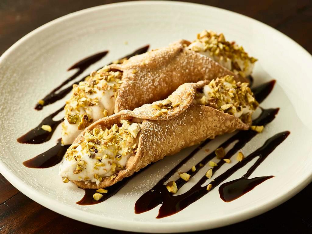 Traditional Cannoli · Two crisp pastry shells stuffed with sweet ricotta and chocolate chip  filling, topped with pistachios and powdered sugar.