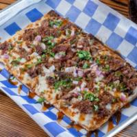 The Texan Flatbread · Smoked Brisket or Chik'N, Jack Cheese, BBQ Sauce, Red Onions and Cilantro