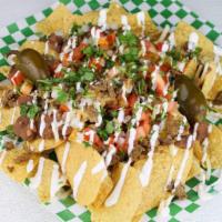 Nachos · Tortilla chips with pinto beans, Jack cheese, your choice of meat, tomatoes, onion, sour cre...