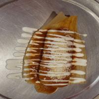 BEEF TAMALE · A thin crepe tamales Meño's style topped with our enchilada sauce, cotija cheese and sour cr...