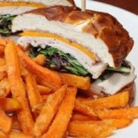 Cranberry Turkey Sandwich · Honey smoked turkey, peppered bacon, cheddar cheese, cranberry mayo and field greens on a wa...