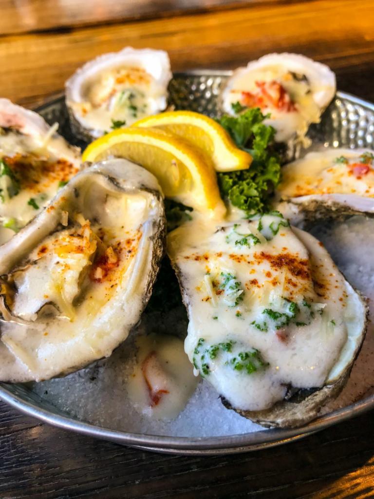 Rockefeller Oysters · 6 Buttery Local oysters topped with creamy Parmesan, wilted baby spinach and garlic with crispy pancetta.