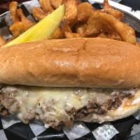 French Dip Sandwich · Shaved ribeye with sauteed onions, Swiss cheese, and white Cheddar sauce on a warm French ba...