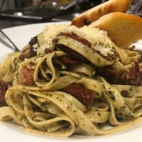 Pesto Fettuccine · Fettuccine pasta tossed in pesto sauce with sun-dried tomatoes and crispy pancetta. Topped w...