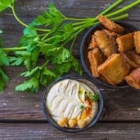 Pita Chips · Comes with a small dip, your choice of hummus, tzatziki, or garlic sauce.