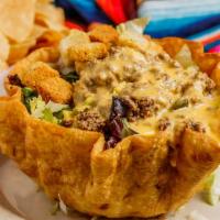 Dirty Taco Salad · Large crispy tortilla bowl smothered with refried beans, filled with fresh greens, topped wi...