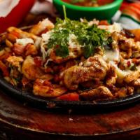 Gringos Fajitas · Grilled chicken and shrimp cooked with pico de gallo, mushrooms and bacon, topped with white...